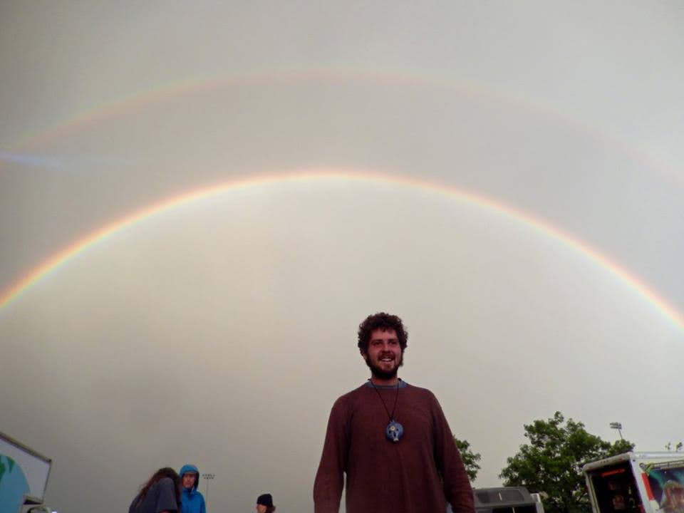 Old picture of me smiling with double rainbow in background.